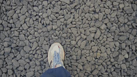 man-walking-on-black-and-white-stones