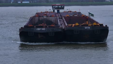 Goods-barge-sailing-across-Oude-Maas-river,-vessel-deck-vacant-for-cargo