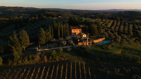 Panoramic-aerial-descends-to-villa-overlooking-olive-trees-in-Tuscan-countryside-of-Certaldo