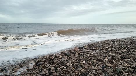 Sandy-waves-slow-motion-crash-onto-Rhyl-pebble-beach