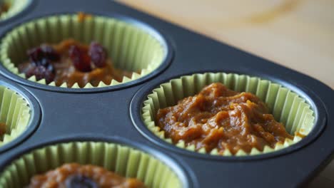 Adding-raisins-to-batter-inside-of-pan-for-vegan-pumpkin-muffins-using-real-roasted-pumpkin-in-bowl-healthy-dairy-free-recipe-vegan
