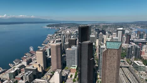Aufsteigende-Luftaufnahme-Der-Wolkenkratzer-In-Der-Innenstadt-Von-Seattle-Mit-Blick-Auf-Den-Puget-Sound-An-Einem-Sonnigen-Tag