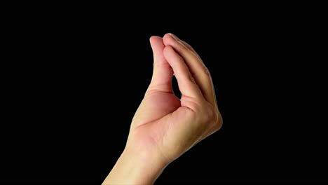 Close-up-shot-of-a-male-hand-throwing-an-Italian-style-perfect-sign,-against-a-plain-black-background