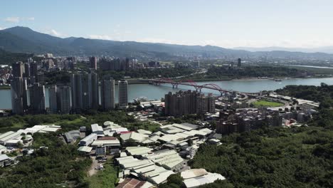 El-Paisaje-Urbano-De-Taipei,-El-Puente-Guandu-Y-Las-Montañas-Crean-Un-Vibrante-Espectáculo-Aéreo