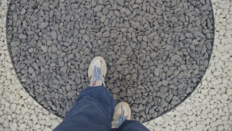 man-walking-on-black-and-white-stones