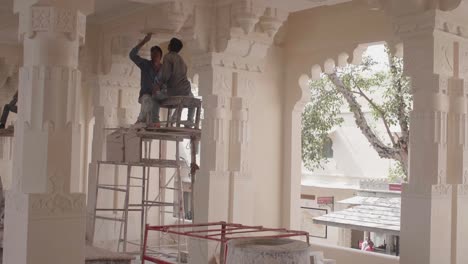 Skilled-workman-meticulously-restore-the-intricate-inside-of-temple-ceiling