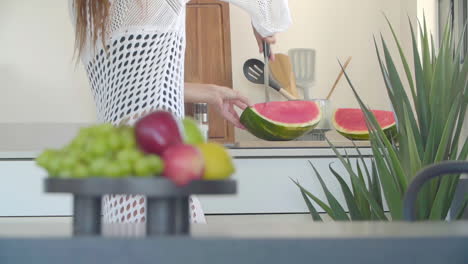 Halbkörperansicht-Einer-Frau,-Die-In-Der-Küche-Frische-Wassermelone-Schneidet