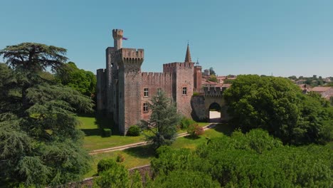 Castillo-Medieval-De-Pouzilhac-Con-Un-Telón-De-Fondo-Verde---Aéreo
