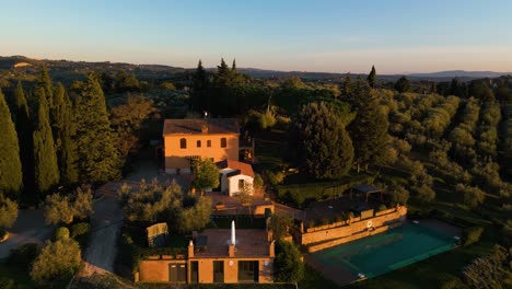 Golden-hour-light-spread-across-classic-Tuscan-Villa-on-outskirts-of-Certaldo-amongst-olive-trees