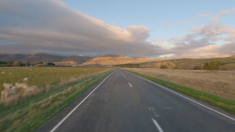 POV-Desde-Un-Automóvil-Conduciendo-Por-La-Carretera-Estatal-85-A-Lo-Largo-De-La-Llanura-De-Maniototo-En-Otago,-Nueva-Zelanda