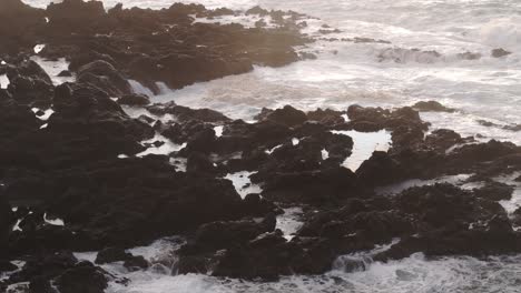 Wave-crashing-into-the-rocky-coastline-at-Flores-island,-aerial