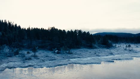 Indre-Fosen,-Trondelag-County,-Norway---The-Wintry-Lakeshore-of-Omundvatnet,-Observed-During-the-Onset-of-Dusk---Drone-Flying-Forward