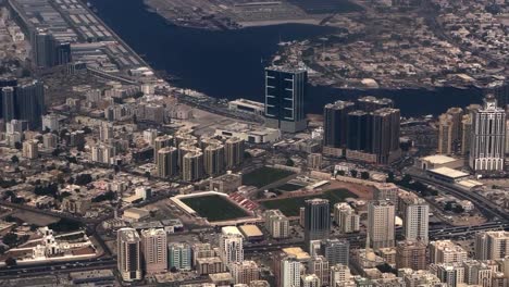 Aerial-drone-view-of-Dubai-is-moving-towards-Karne-Raho-side-where-many-big-buildings-are-visible-and-there-are-many-trees-and-a-big-beach-is-also-visible