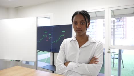 Black-African-business-woman-looking-at-camera-with-a-trading-view-graphic-in-the-background-serious-face-expression