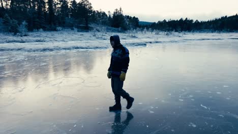 Indre-Fosen,-Trondelag-County,-Norway---A-Man-Strolling-Across-the-Icy-Surface-of-Omundvatnet---Tracking-Shot