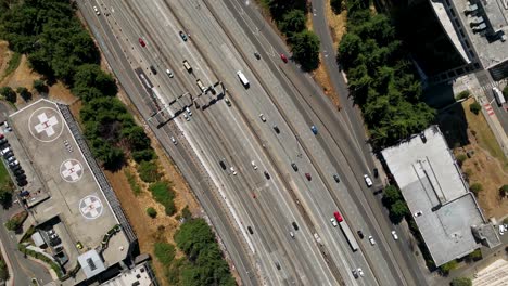 Top-down-drone-shot-of-cars-traveling-on-Interstate-5,-through-Seattle's-downtown-area