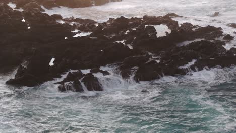 Waves-crashing-into-rocky-coastline-at-Flores-island-Azores---Drone-shot