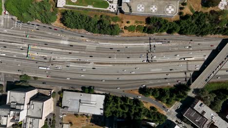 Aerial-time-lapse-of-cars-driving-along-the-freeway-through-Seattle's-downtown-neighborhood