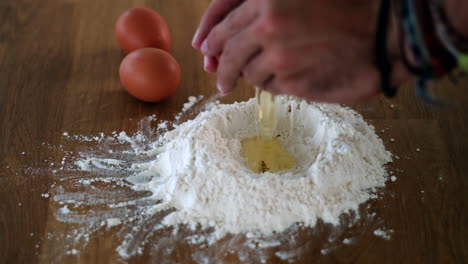 Making-pasta-dough-with-eggs-and-flour-on-board
