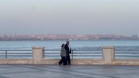 An-adult-couple-is-walking-on-a-cinematic-beach-view