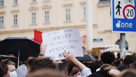 A-slow-motion-shot-of-a-angry-man-holding-a-sign-and-protesting-against-racism-in-Vienna,-Austria