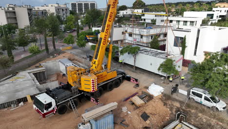 Huge-yellow-crane-transporting-and-positioning-prefabricated-modular-house