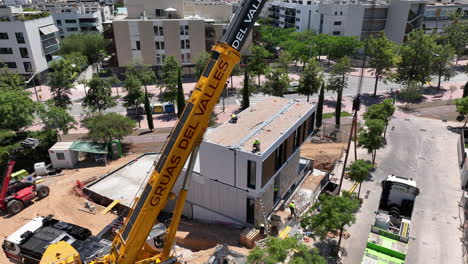Crane-positioning-prefabricated-modular-house-in-construction-site