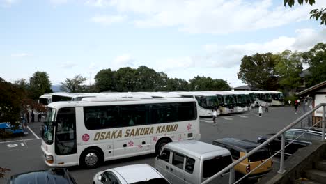 Tourist-Bus-Leaving-Past-Rows-Of-Parked-Coaches-At-Kiyomizu-zaka-Parking-Lot