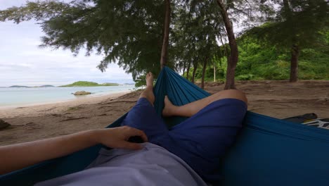 POV-of-a-man-lying-in-his-hammock-relaxing-while-resting-near-the-tropical-beach