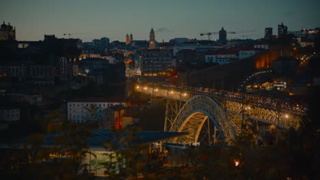 Warme,-Malerische-Aufnahme-Der-Brücke-Dom-Luís-I-Mit-Lichtern-Und-Der-Skyline-Von-Porto-Im-Hintergrund