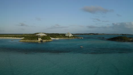 Pequeño-Barco-Acercándose-A-Tierra-En-Las-Islas-Tropicales-Exumas-Bahamas,-Aéreo