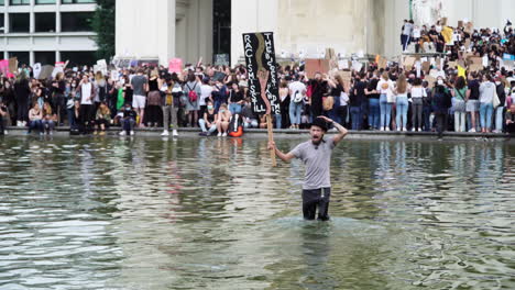 A-young-man-is-demonstrating-emotionally-against-violence-and-racism-while-stand-in-the-knee-deep-water