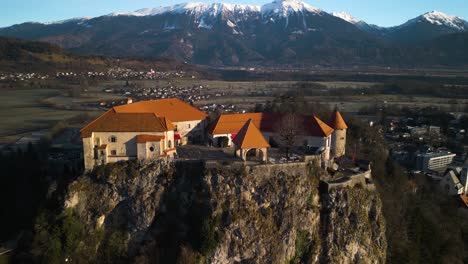 Filmische-Luftaufnahme-über-Der-Wunderschönen-Burg-Von-Bled-Auf-Einem-Felsen-In-Slowenien-In-Der-Nähe-Der-Julischen-Alpen