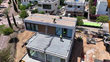 Aerial-top-down-view-of-prefabricated-modular-house-with-workers-working-in-construction-site