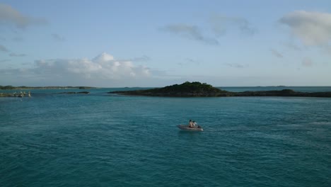 Menschen-Auf-Einem-Aufblasbaren-Floßboot-Mit-Exotischem-Bahamas-Inselhintergrund,-Luftaufnahme