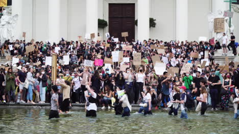 A-couple-of-young-people-are-demonstrating-in-the-knee-deep-water-in-front-a-an-important-building-in-Vienna