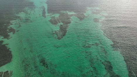 Drone-view-in-Belize-flying-over-caribbean-dark-and-light-blue-sea-top-view-shallow-water-coral-reef