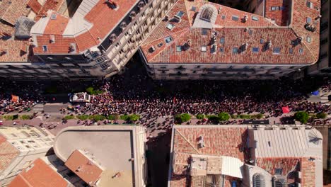 Gay-pride-parade-participants-march-on-streets,-captured-in-top-down-aerial-view