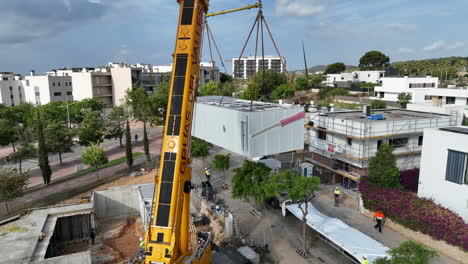Powerful-crane-positioning-pre-fabricated-modular-house-to-construction-site