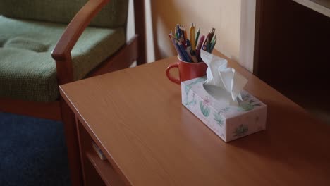 Papiertaschentücher-Und-Buntstifte-Auf-Einem-Tisch,-Um-Den-Herum-Stühle-Stehen