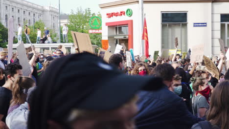 A-shot-of-a-dense-crowd-wearing-masks-for-protection-and-protesting-against-racism-while-walking-down-a-famous-street-in-Vienna
