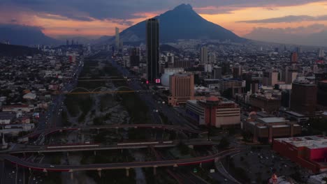 Ruhender-Vulkan-Cerro-De-Topo-Chico-In-Silhouette-Mit-Verblassendem-Sonnenuntergang-Im-Hintergrund-Und-Der-Stadt-Monterrey,-Nuevo-Leon-Im-Vordergrund