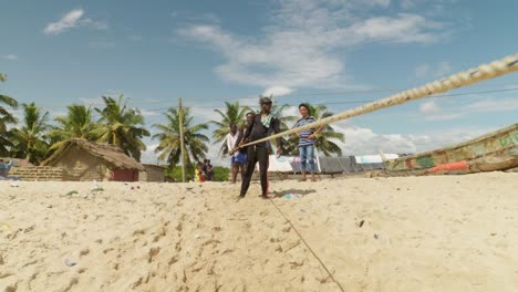 Junge-Männer-Ziehen-Fischernetze-Per-Seil-Zum-Sonnigen-Sandstrand-In-Moree,-Ghana