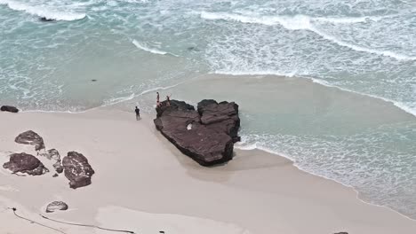 Beach-with-a-heart-shaped-rock,-family-on-the-heart-shaped-rock-taking-pictures