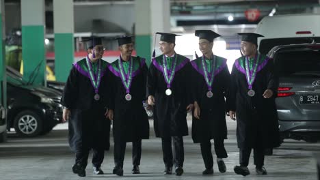Graduados-Con-Sombreros-Negros-Con-Un-Vestido-De-Graduación-Universitaria,-Hablan-Y-Se-Divierten