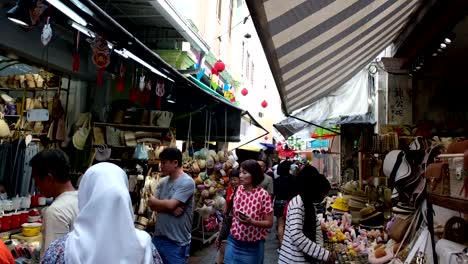 A-lane-full-of-sidewalk-vendors-displaying-their-stuff-while-the-crowds-are-walking-back-and-forth