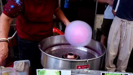 A-person-making-cotton-candy-in-front-of-the-public