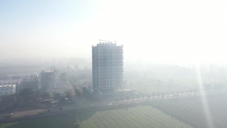 aerial-drone-shot-is-moving-to-the-side-and-a-building-is-visible-in-the-middle-and-its-rays-are-falling-on-that-building-cinematic-shot-of-high-rise-building-is-visible