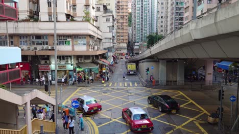 Traffic-Turning-Left-On-Tong-Shui-Road-With-Overpass-Road-Above-In-North-Point,-Hong-Kong