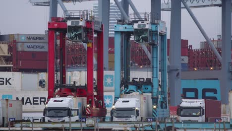 Kräne-Heben-Versandcontainer-Im-Hafen-Von-Aarhus-An,-Im-Hintergrund-Wird-Das-Mearsk-Schiff-Beladen